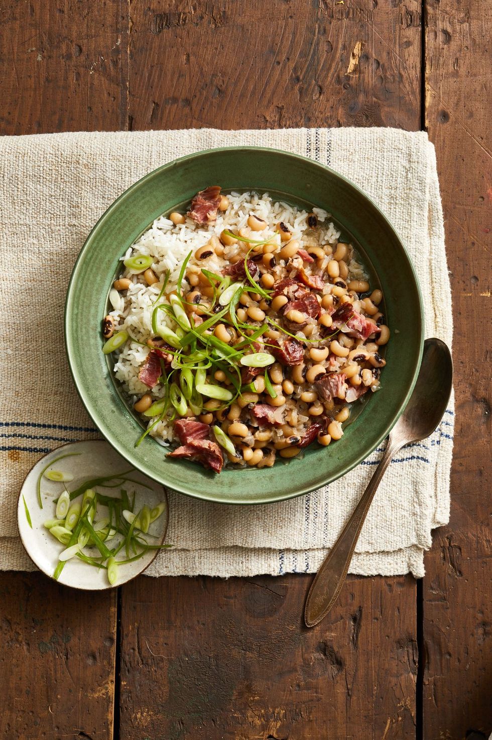 black eyed peas over rice in a green bowl