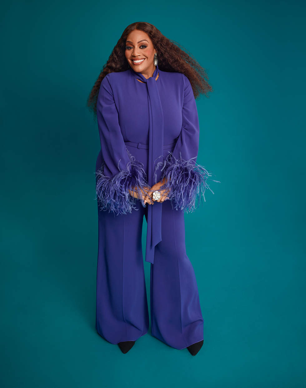 person wearing a stylish purple outfit with feathered sleeves