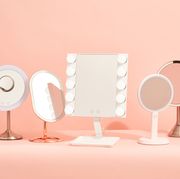five vanity mirrors with lights on a pink background, good housekeeping's picks for the best vanity mirrors with lights