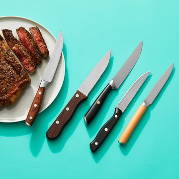 steak knives next to a plate with a sliced steak
