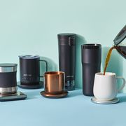a collection of heated mugs with a hand pouring coffee into one of them