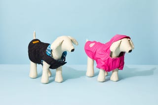 black and pink dog jackets on white dog mannequins, against a blue background, for the good housekeeping picks for best dog jackets