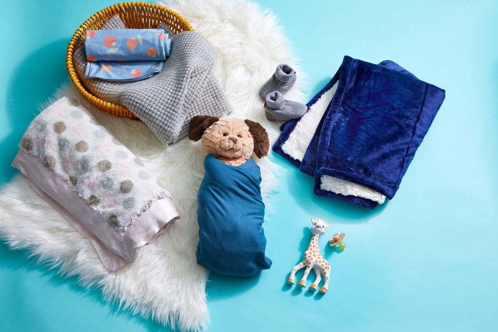 a stuffed puppy swaddled in a copper pearl swaddling blanket, part of a good housekeeping institute box about when babies can safely sleep with a baby blanket
