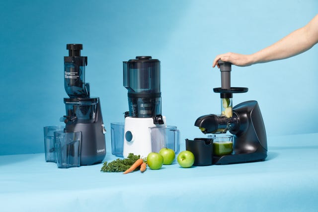 three juicers juicing vegetable juice