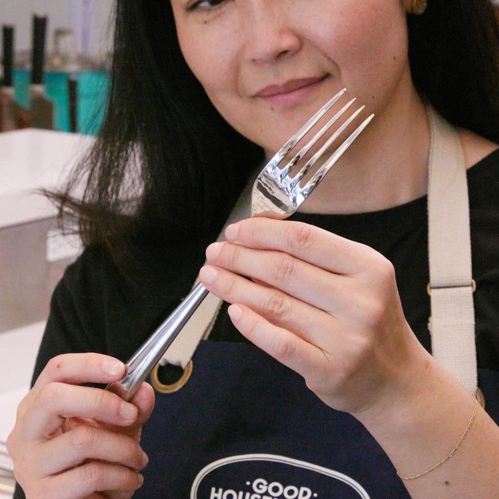 best flatware sets person inspecting a silver fork in their hands