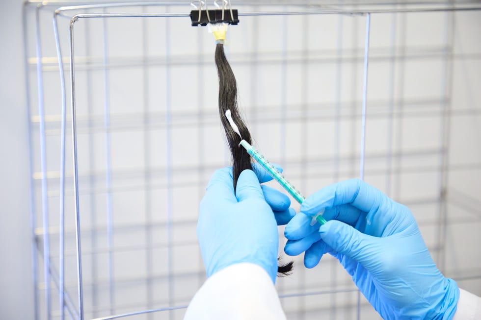 a photo of anti frizz products being tested on hair swatches in the good housekeeping beauty lab