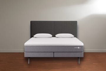 a sleep number p6 mattress on bed base, on wood floor against a white wall