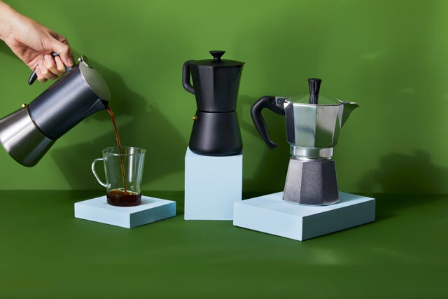 two moka pots on blue blocks and one moka pot held pouring coffee