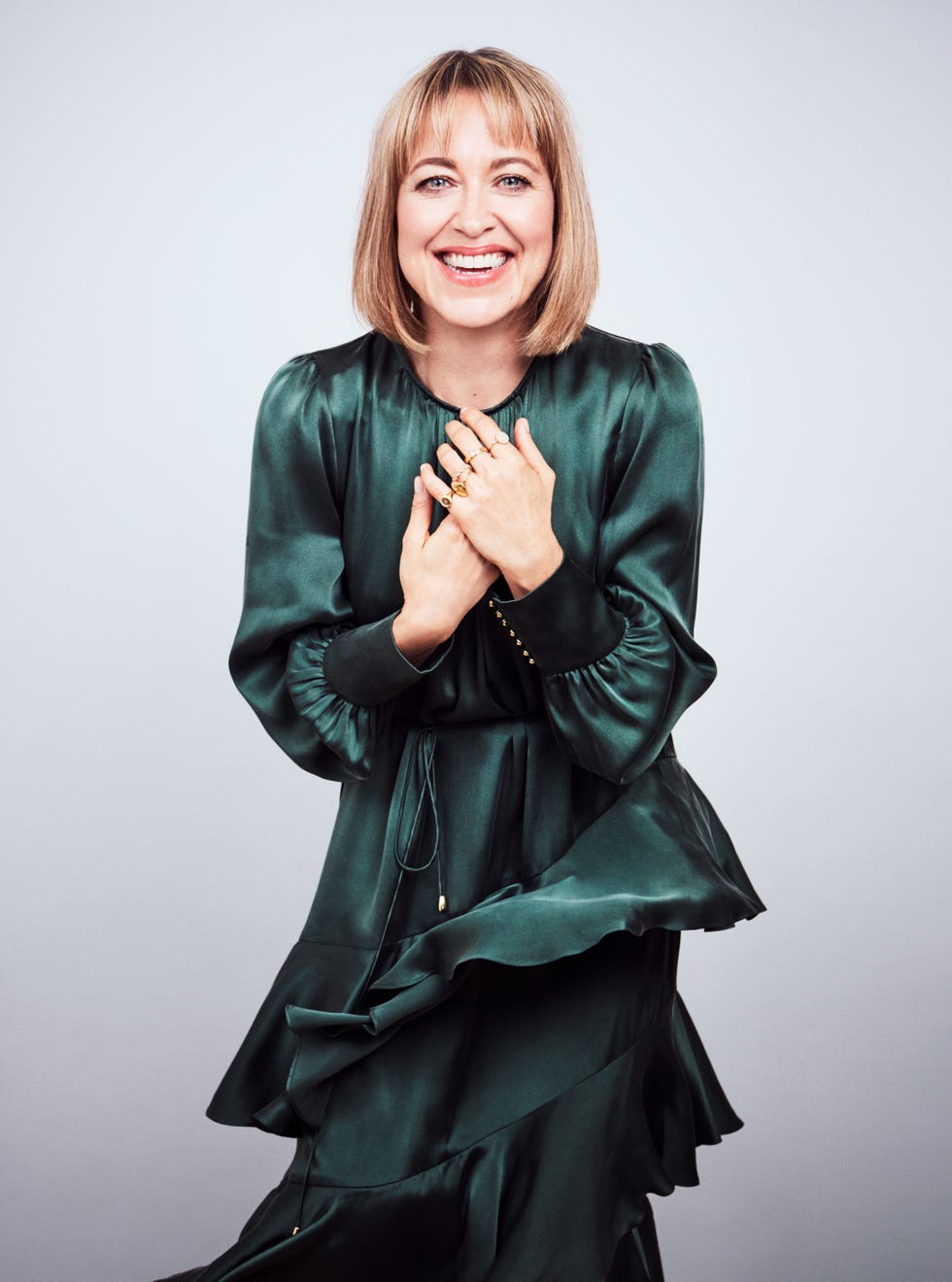 a person in a stylish green dress appearing thoughtful or reflective
