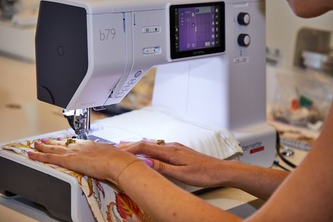 a lab analyst is sewing with floral fabric to test the best sewing machines for good housekeeping