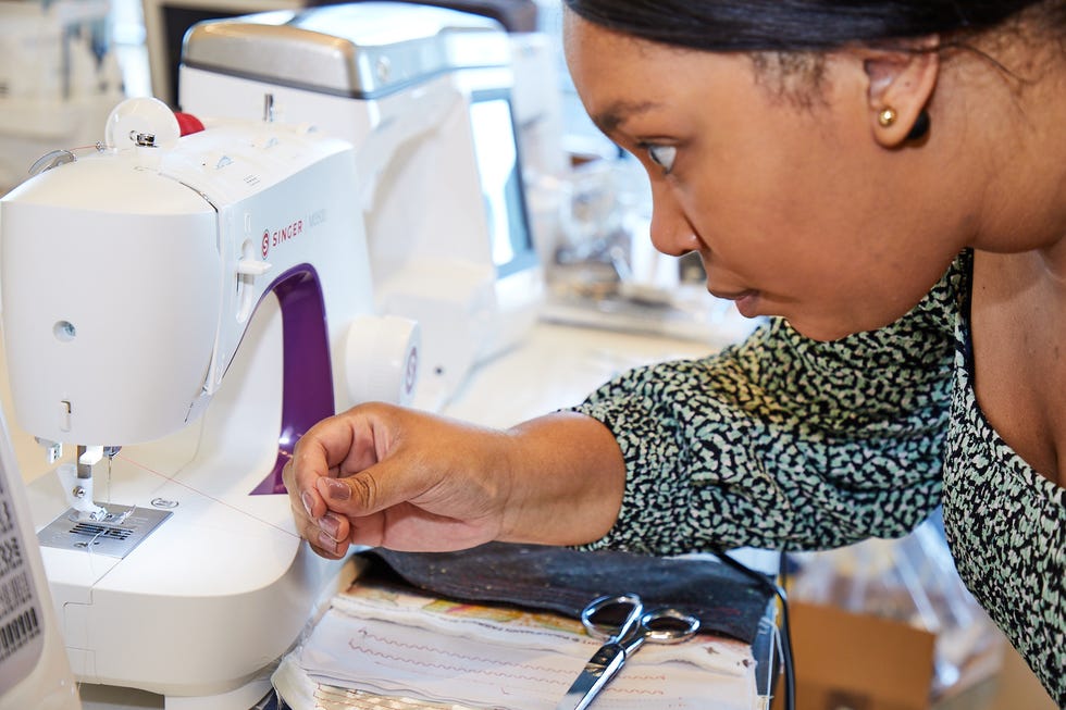 gh analyst is threading a sewing machine to evaluate ease of threading as part of good housekeeping's testing to find the best sewing machines for quilting
