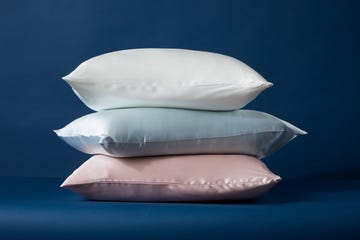 Three stacked pillows in pastel colors against a dark background