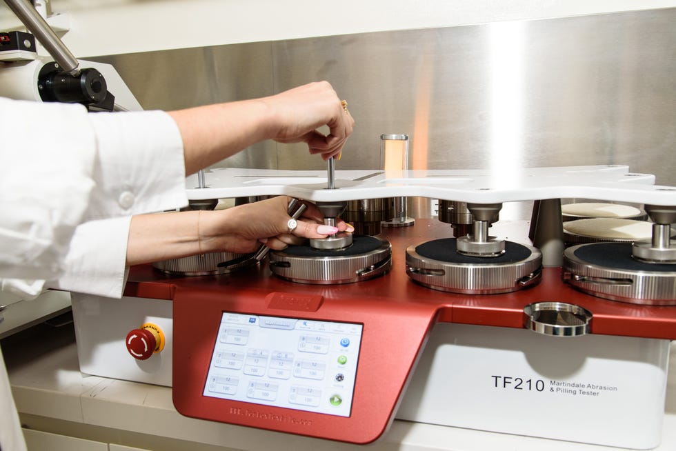 a textiles lab analyst setting up our martindale abrasion tester