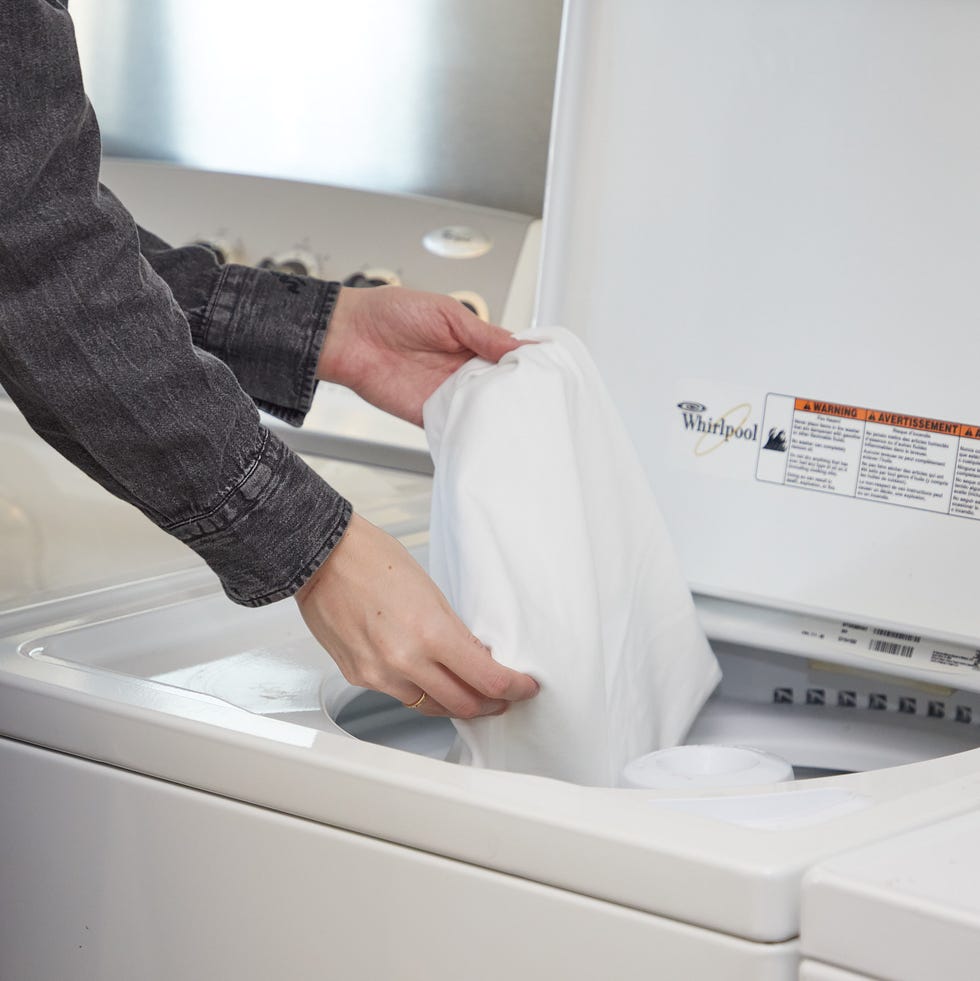 best white t-shirts for women - testing a gh analyst placing a t shirt in the washing machine
