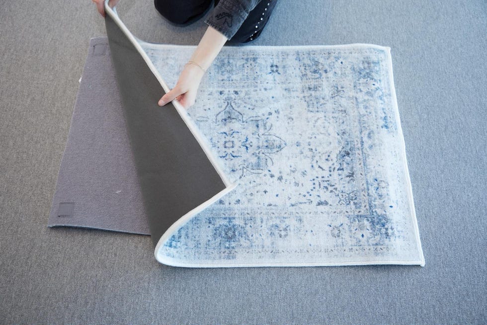 a gh analyst piecing together two layers of a light blue and white ruggable rug