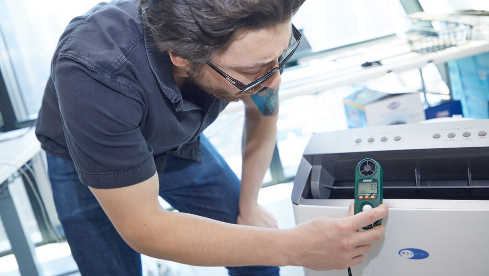 portable air conditioner testing an expert measures the air speed coming off a portable air conditioner
