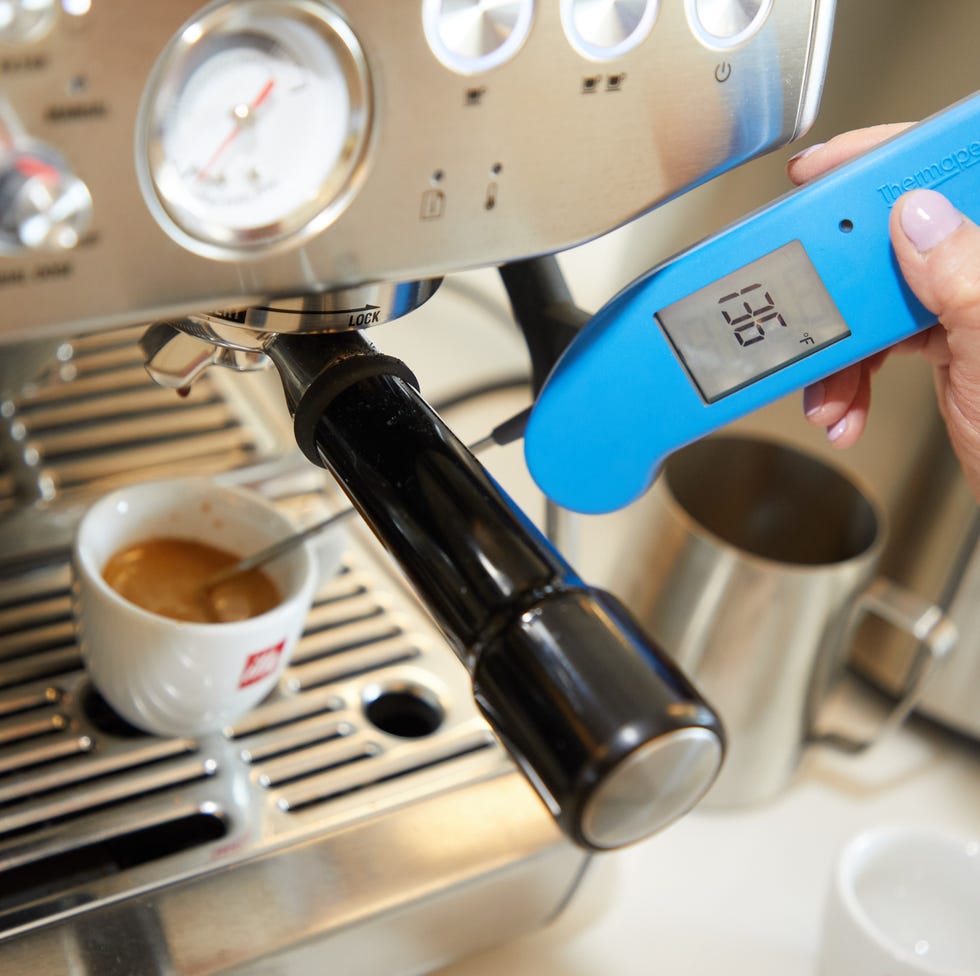 Espresso machine testing taking the temperature of a shot of espresso