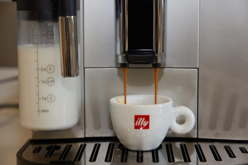 coffee brewing process with a cup under an espresso machine spout