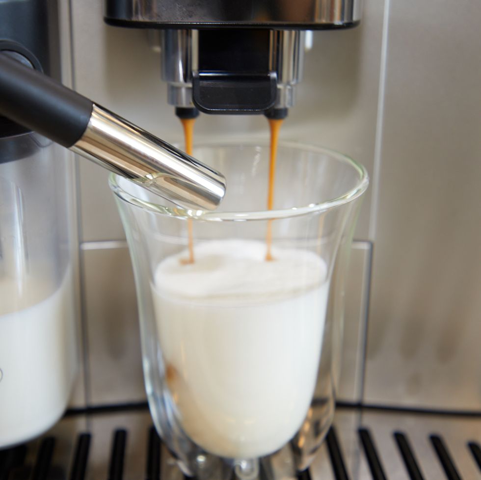 machine making espresso and milk froth that is dispensed into a glass