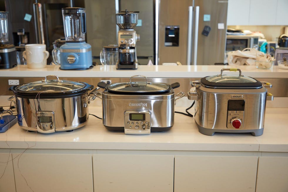 Three slow cookers on a kitchen counter