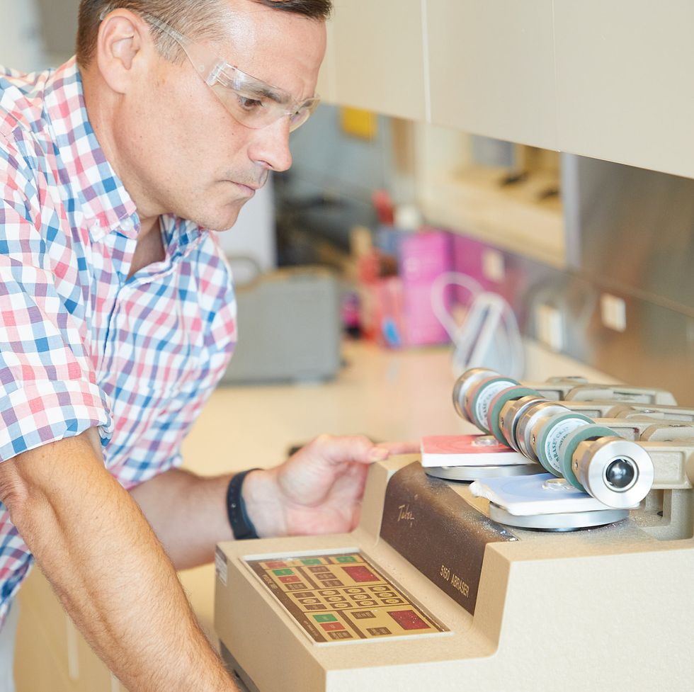 an expert uses an abrasion machine to test paint testing