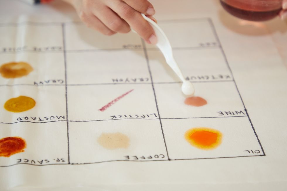 tester applying stains to a swatch to test ecofriendly laundry detergents
