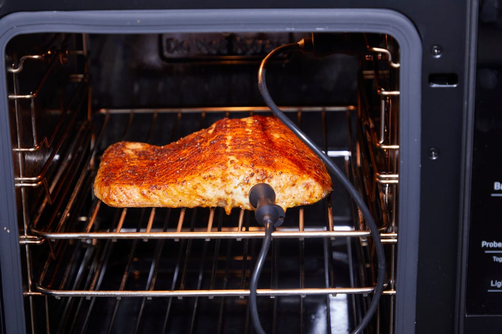 salmon fillet cooking in an oven with a probe thermometer