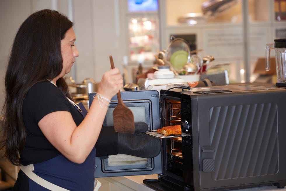 a person using a spatula to take food out of an oven