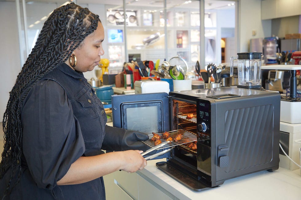 person using an oven to remove cooked food in a kitchen setting