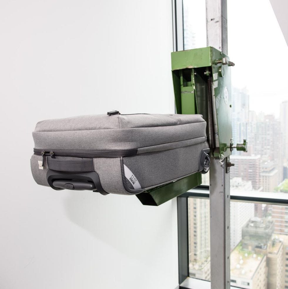 a grey suitcase place on the drop tester to evaluate durability