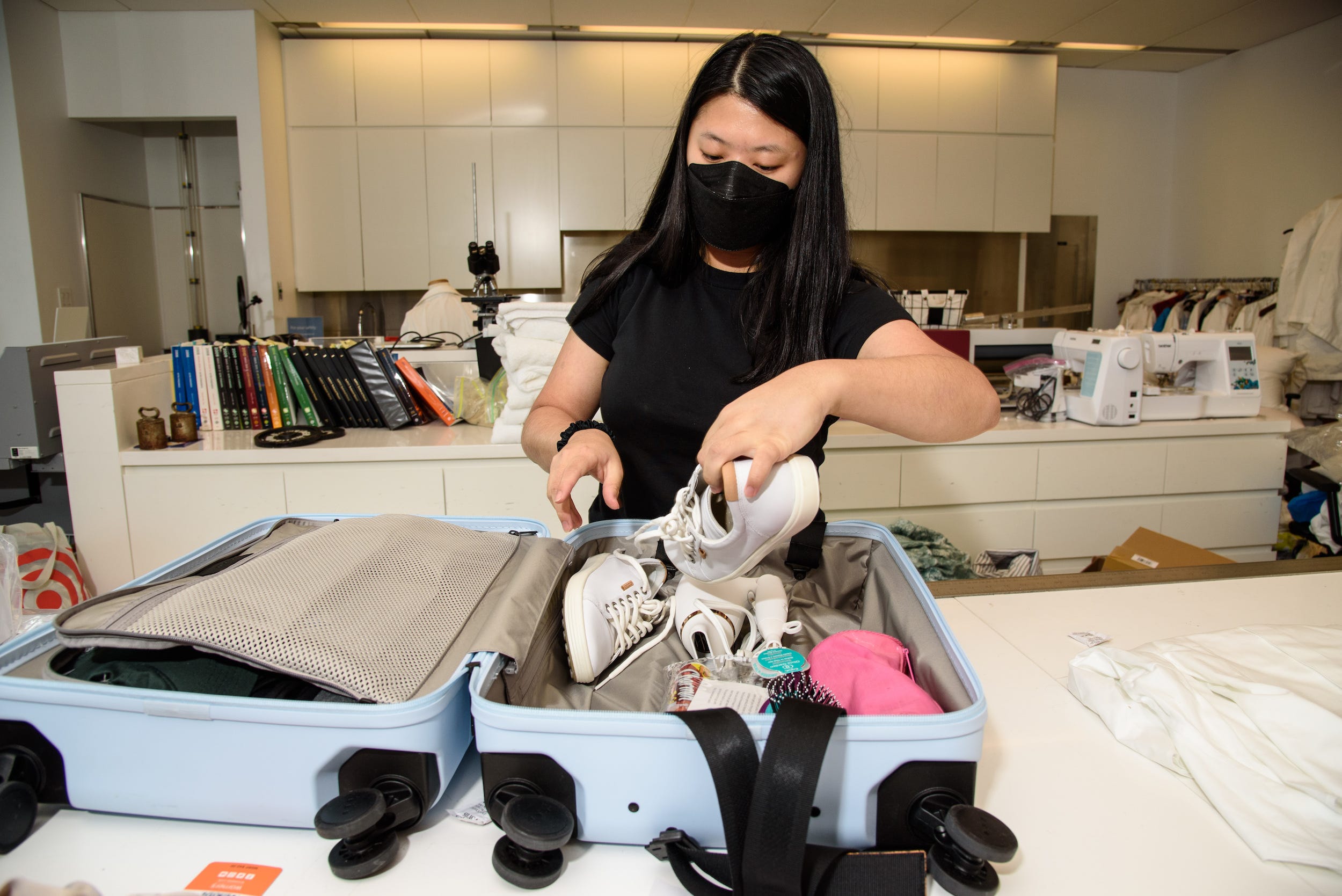 gh textiles lab analyst packing a suitcase for luggage testing