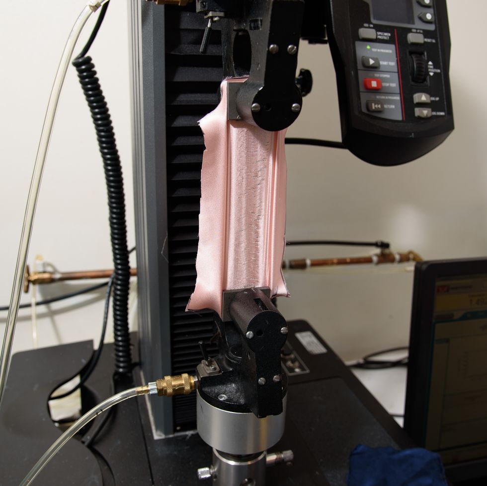 a pink silk pillowcase fabric in an instron machine, showing how the good housekeeping institute textiles lab tests fabric strength of silk pillowcases
