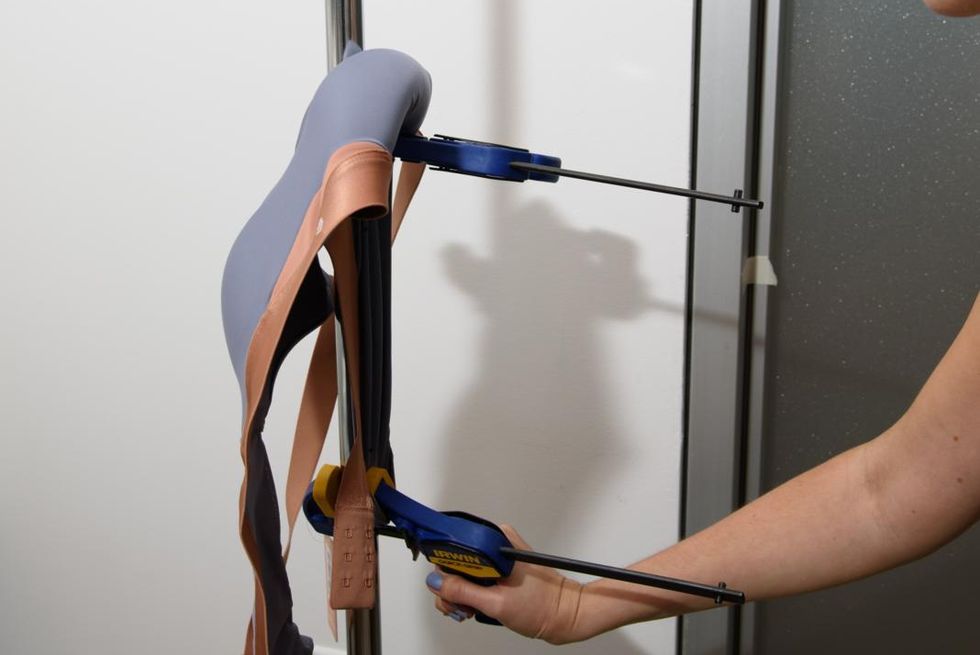 a sports bra clamped into place during a stretch recovery test, part of good housekeeping's evaluations for finding the best sports bras