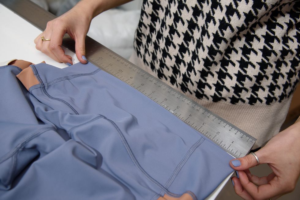 a good housekeeping analyst measuring the waistband on a pair of leggings as part of good housekeeping's best lululemon leggings test