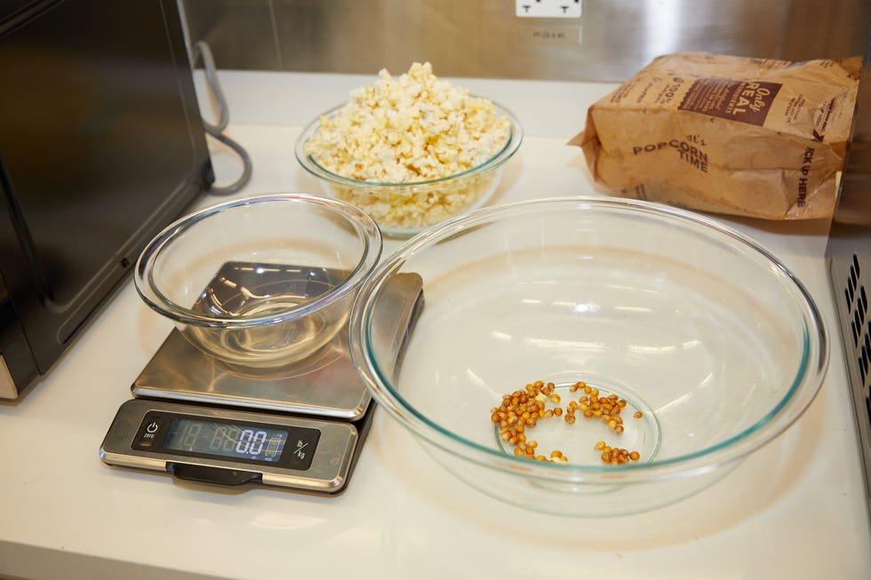 empty bowl on a kitchen scale next to a bowl filled with kernels and another bowl filled with popped popcorn