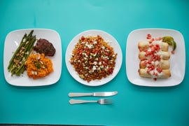 prepared dishes on a blue background for good housekeeping best meal delivery services testing