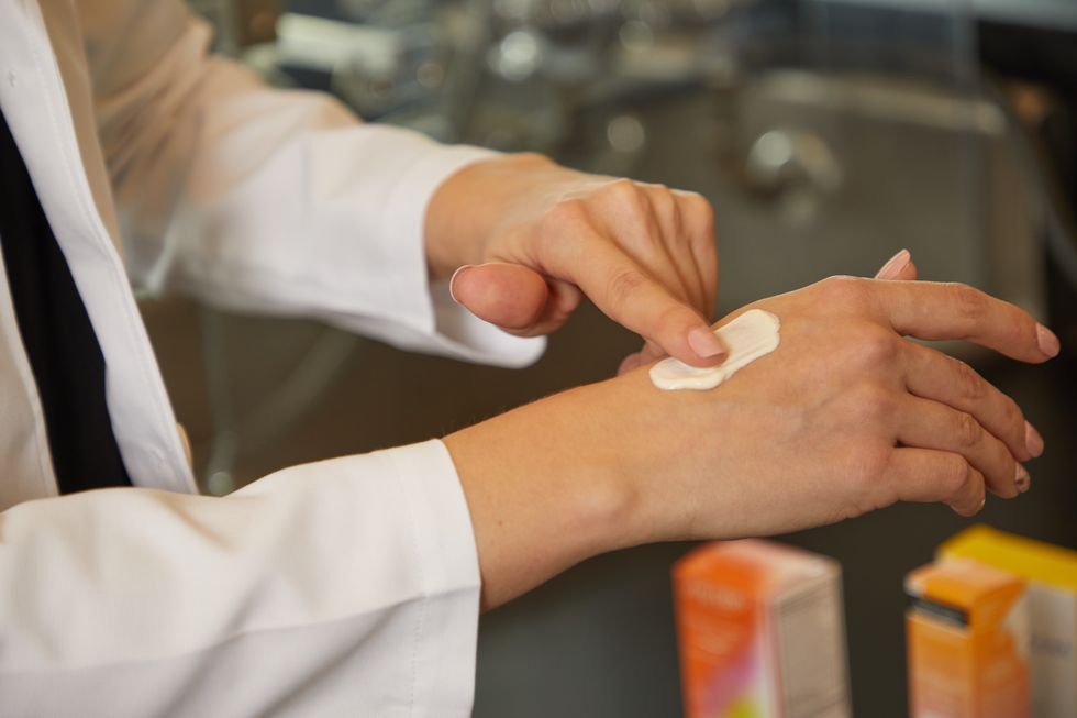 an image of a good housekeeping beauty lab scientist's hand testing a sunscreen