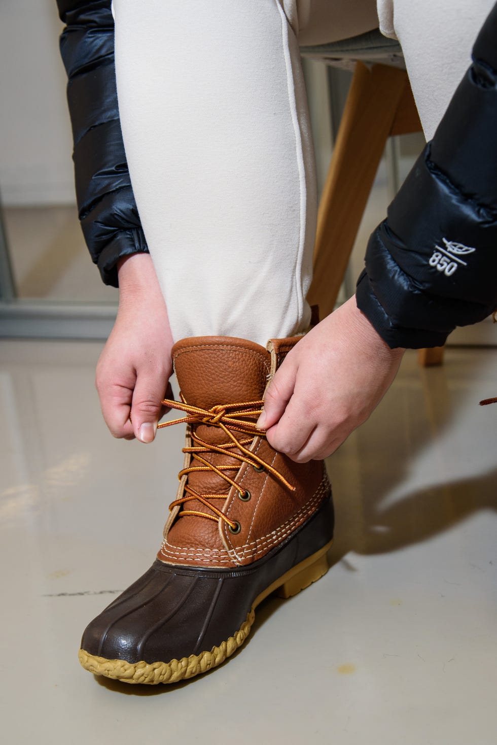 a textiles lab analysts tightens laces on a winter boot to gauge how easy it is to adjust the fit