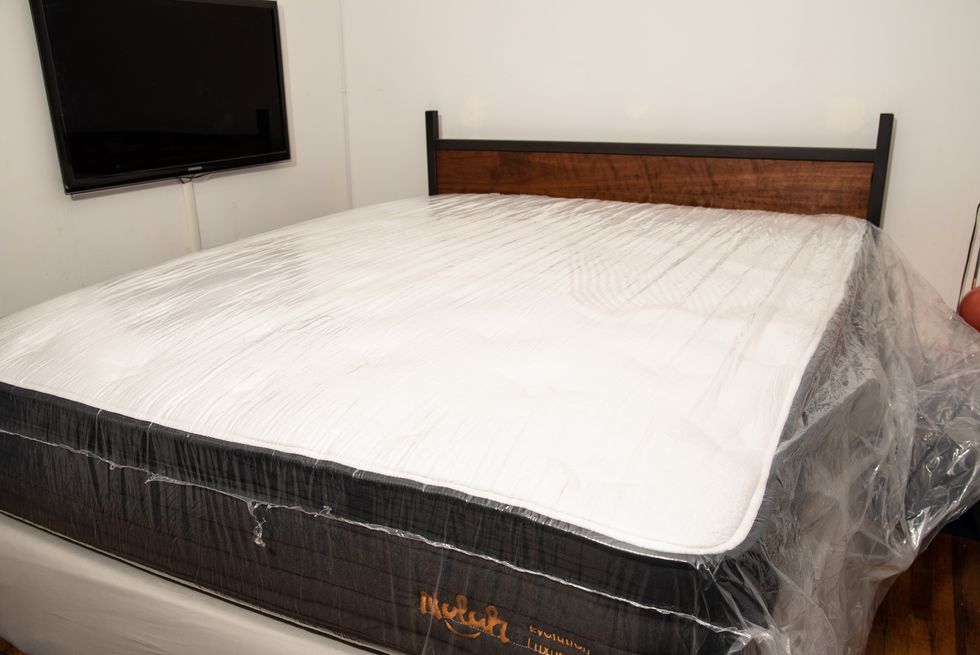 a mattress in plastic inflating on a bed frame