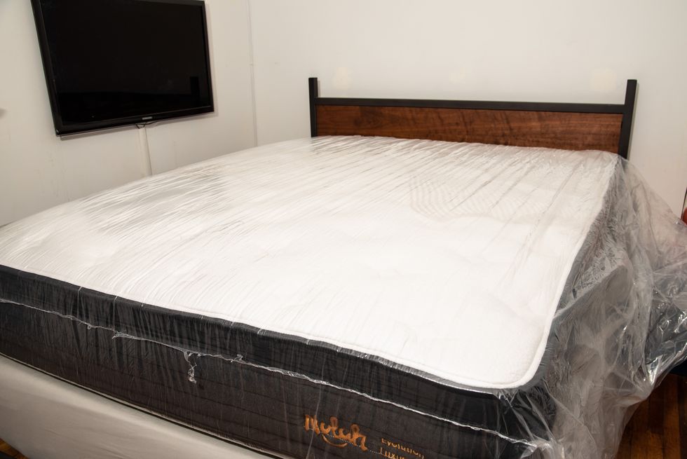 a mattress in plastic inflating on a bed frame