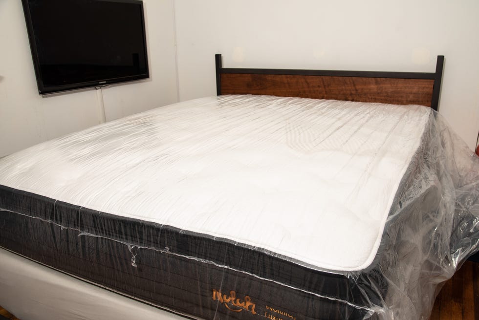 best firm mattress - how we test a mattress in plastic inflating on a bed frame