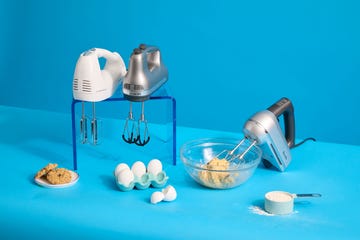 three hand mixers surrounded by eggs, flour and cookies