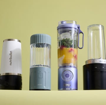 Best Portable Blenders four portable blenders side by side with a bowl of frozen strawberries and smoothie ingredients in one blender