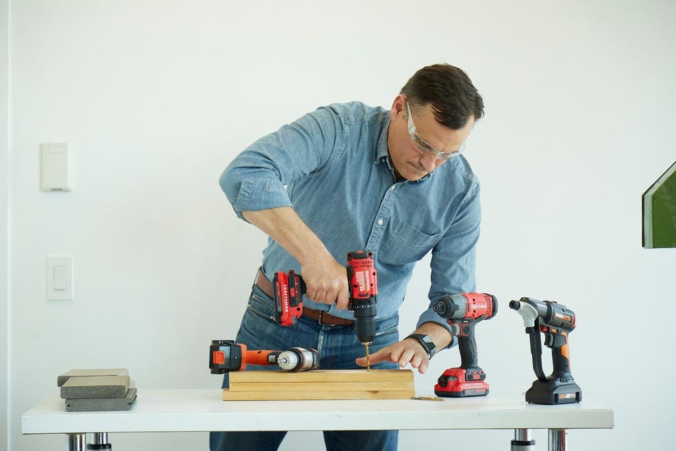 a person using a drill while working on a wooden project
