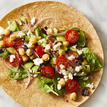 greek salad in a wrap with feta cheese crumbled on top