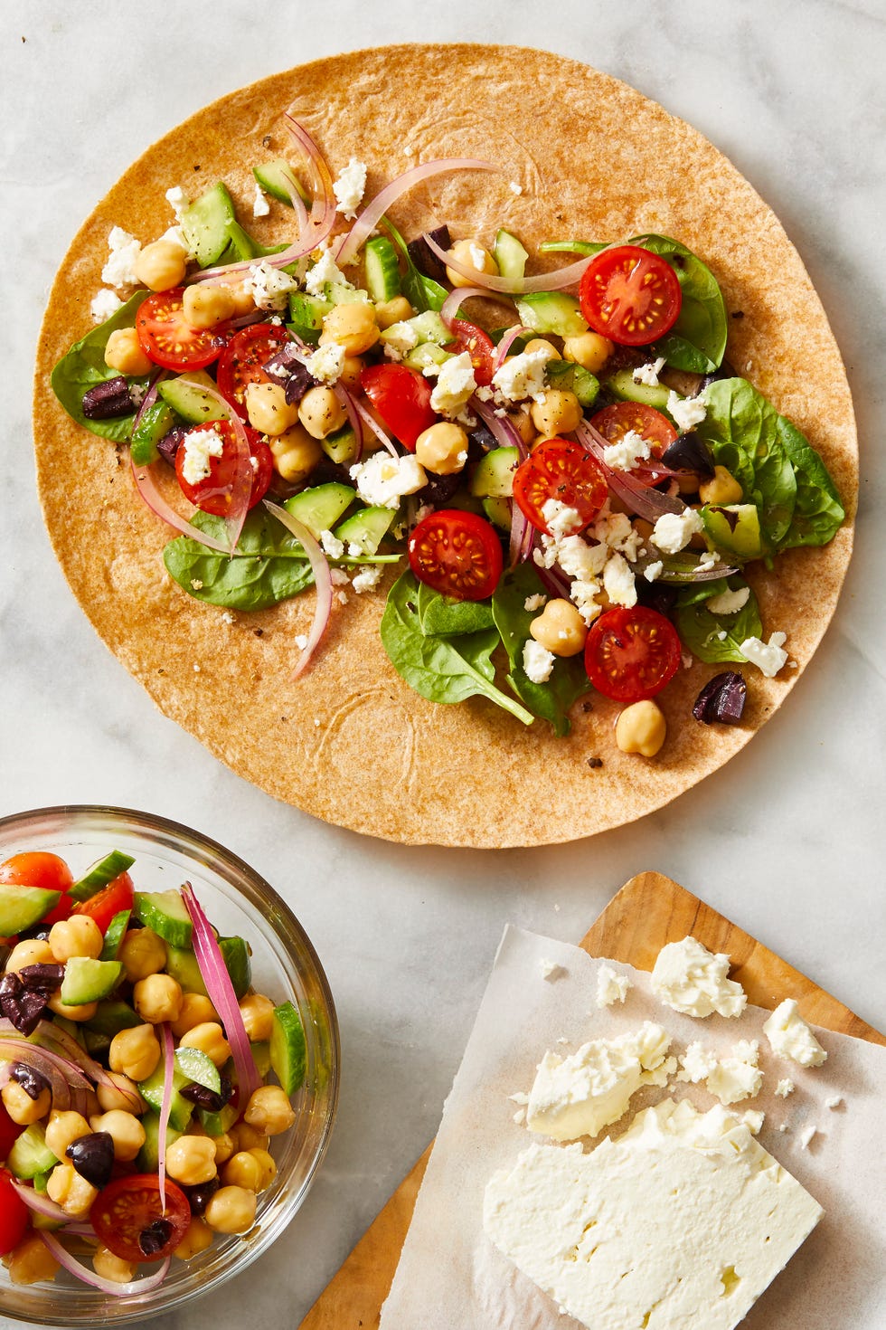 greek salad in a wrap with feta cheese crumbled on top