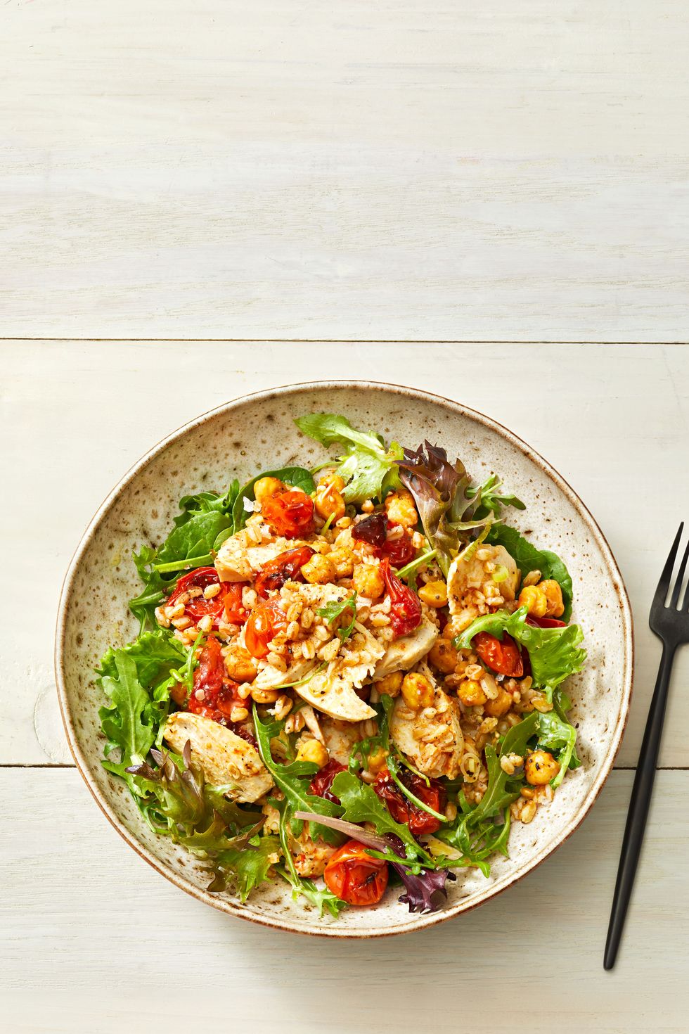 roasted chickpeas, tomatoes and chicken in a bowl with farro and greens