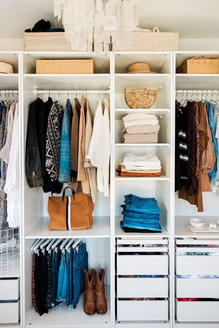 Organized closet with shelves, hangers, storage baskets, drawer storage system and closet organizer