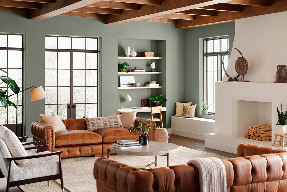 living room with foggy green walls and brown leather sofas