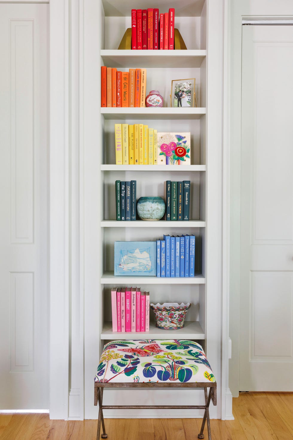 bookshelf with books arranged by color designed by megan evans of megan evans interiors